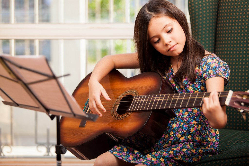 Cute little girl playing the guitar